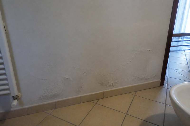 Macchia di umidità e pittura scrostata sul muro — perdita occulta